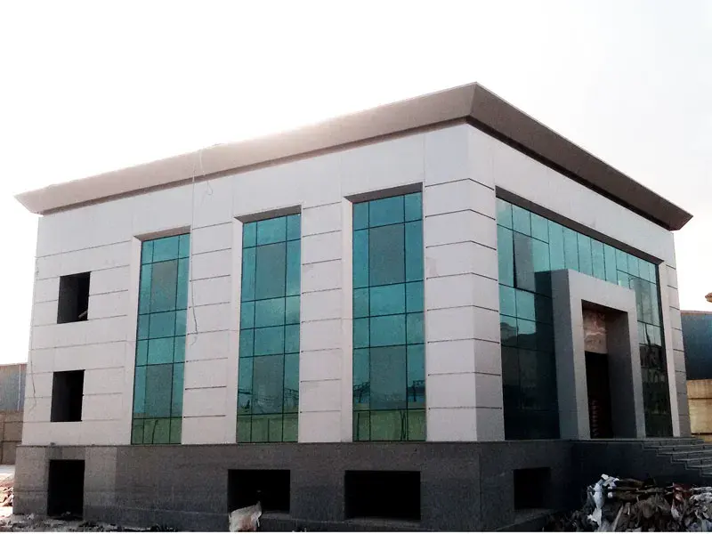 Construction-stage photograph of Al Shady Administrative Building in New Cairo with pale façade panels and tall glazed bays