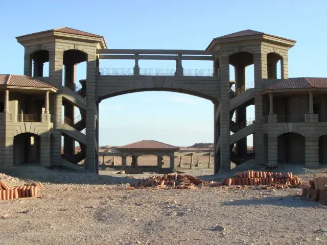 Construction-stage photograph of Beau Rivage Taba Hotel showing a raised bridge between two arcaded hotel wings